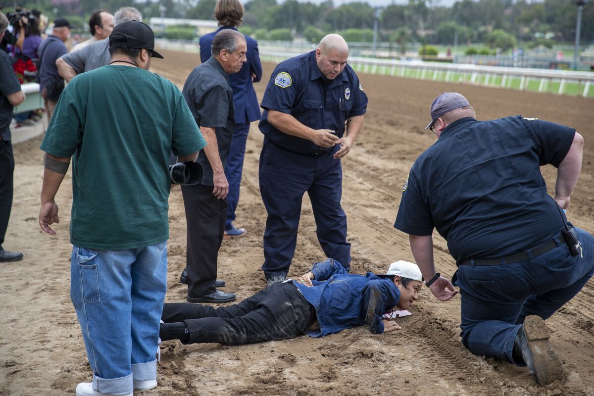 Santa Anita medics attend to an injured photographer after his back was run over by Leucothea on Friday.