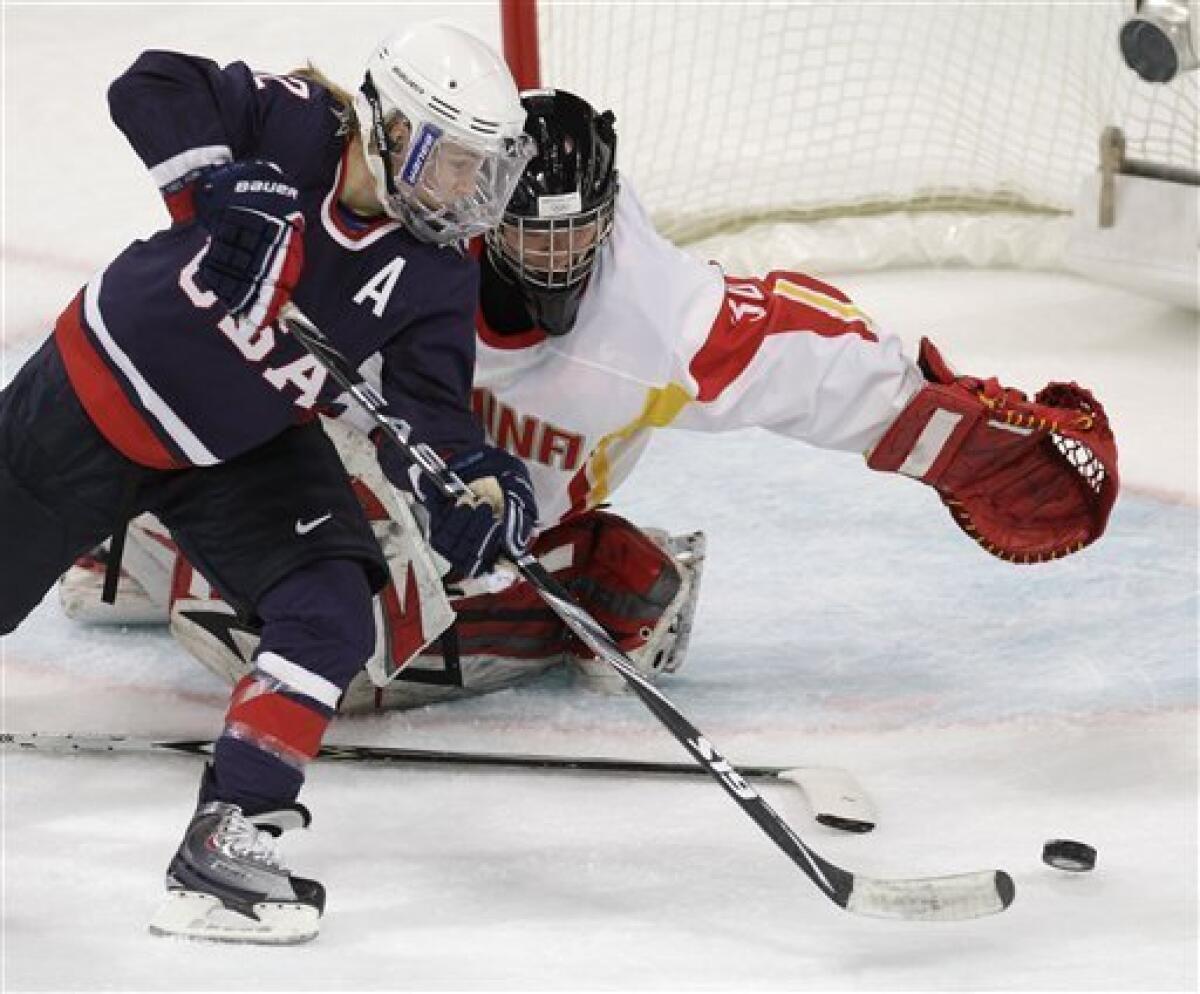 USA's forward Jenny Potter (12) scores past China's goal keeper Shi Yao (30) in the first period in women's preliminary round hockey play at the Vancouver 2010 Olympics in Vancouver, British Columbia, Sunday, Feb. 14, 2010. (AP Photo/Chris O'Meara)