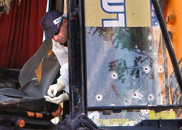 An Israeli police officer picks up shell casings next to the bullet-riddled window of a construction vehicle at the scene of an attack in Jerusalem. A Palestinian from East Jerusalem rammed a construction vehicle into three cars and a city bus in downtown Jerusalem, wounding four people before he was shot dead, in a chilling imitation of a similar attack that took place in the city earlier this month.