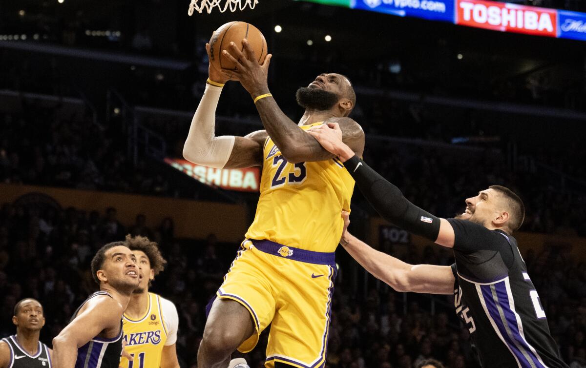 Lakers forward LeBron James is fouled by Kings center Alex Len while driving to the basket. 