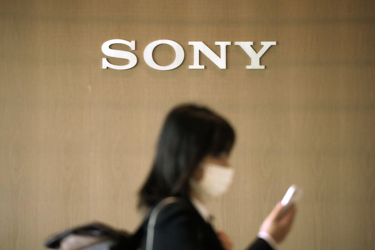 A woman walks at the headquarters of Sony Corp. Tuesday, May 10, 2022, in Tokyo. Sony’s fiscal fourth quarter surged 67% to 111.1 billion yen ($852.7 million) from the previous year, as the Japanese entertainment and electronics company racked up profits in video game and movie divisions, the company said Tuesday, May 10, 2022. (AP Photo/Eugene Hoshiko)