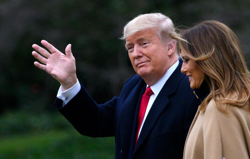 President Trump waves while walking with Melania Trump.