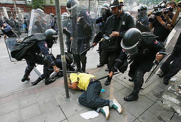 Protest in Thailand - Riot police beat an anti-government protester