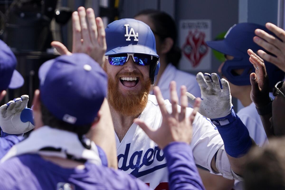 Los Angeles Dodgers' Justin Turner, center is congratulated by teammates in the dugout after hitting a three-run home run during the fourth inning of a baseball game against the Arizona Diamondbacks Wednesday, May 18, 2022, in Los Angeles. (AP Photo/Mark J. Terrill)