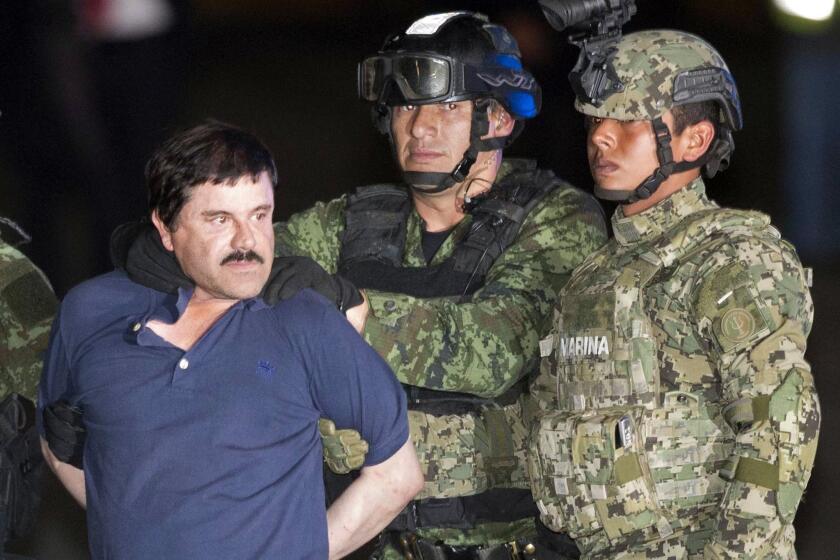 Joaquin "El Chapo" Guzman is escorted to a helicopter in handcuffs by soldiers and marines at a federal hangar in Mexico City on Jan. 8.