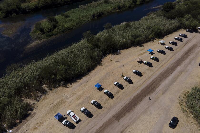 Texas Department of Public Safety vehicles are lined up on the Texas side of the Rio Grande near an area used by migrants, many from Haiti, as an encampment along the Del Rio International Bridge, Friday, Sept. 24, 2021, in Del Rio, Texas. (AP Photo/Julio Cortez)