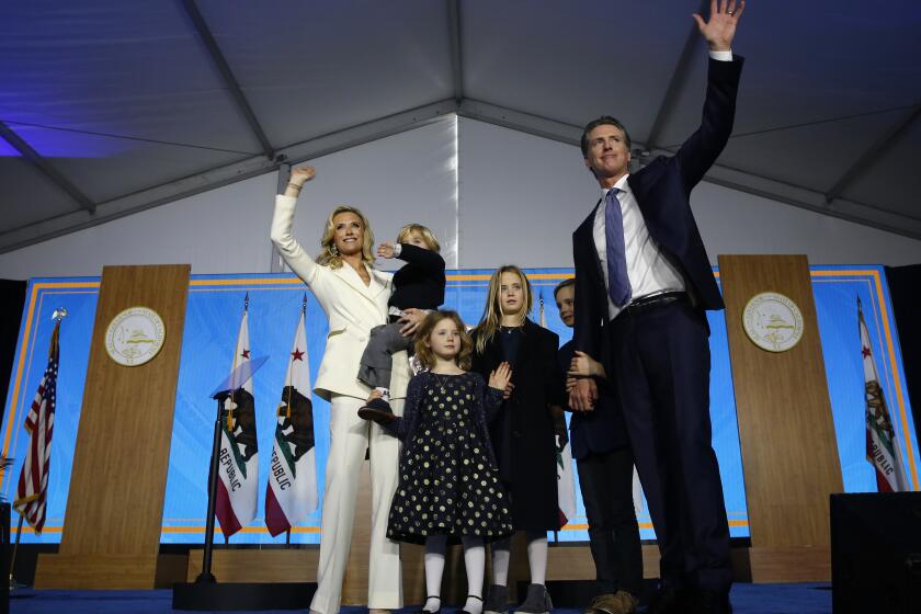 FILE -- In this Jan. 7, 2019, file photo California Governor Gavin Newsom his wife, Jennifer Siebel Newsom, and their children wave after taking the oath office during his inauguration as 40th Governor of California, in Sacramento, Calif. Newsom's office said, Tuesday, July 27, 2021, that he pulled his children out of summer camp after children at the camp weren't wearing face masks, a violation of state policy. (AP Photo/Rich Pedroncelli, File)