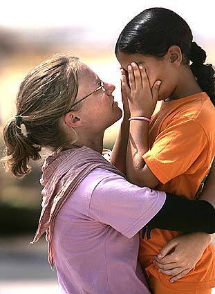 Zimratya Prins, 21, embraces Karmit Cohen, 9, before Karmit left the settlement of Morag with her family. Prins planned to stay until the end.