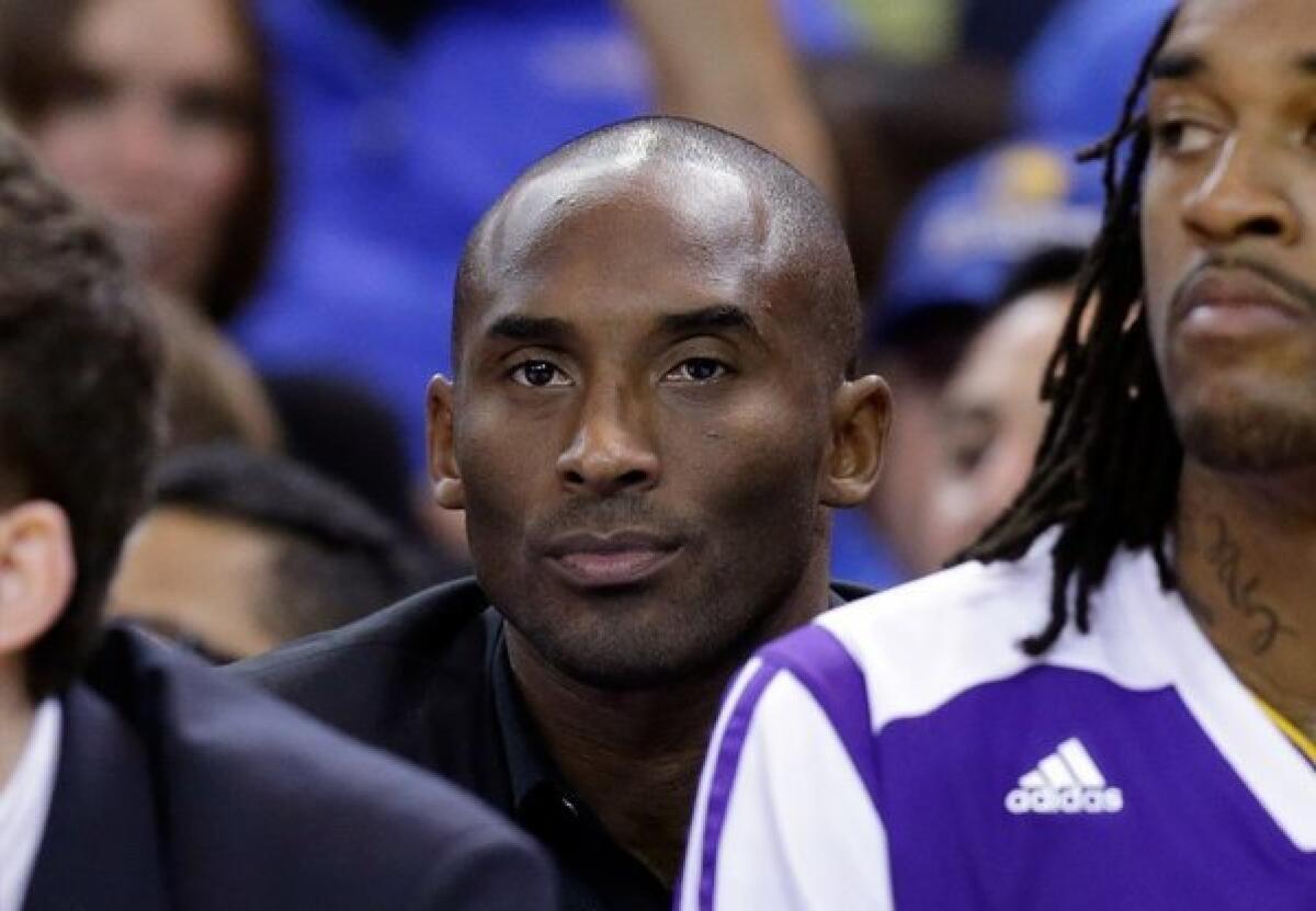 Kobe Bryant, still recovering from a torn Achilles' tendon, can only sit and watch as the Lakers get routed by the Golden State Warriors.
