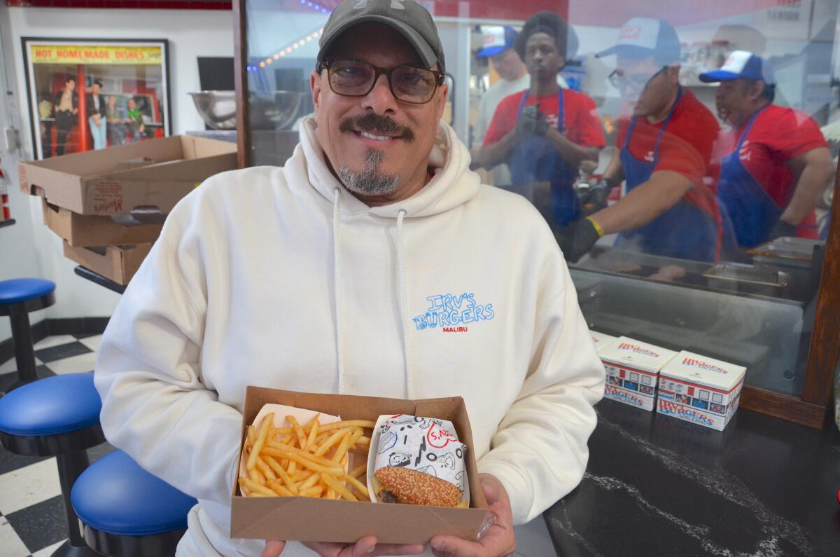 Irv's Burgers' regional area manager, Michael Trimble, holds one of the giveaway burger combo meals.