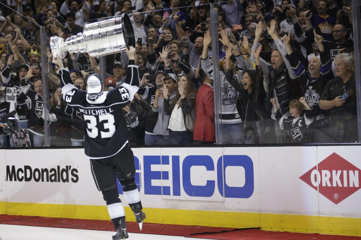 Kings defenseman Willie Mitchell carries the Stanley Cup after beating the New York Rangers in double overtime in Game 5 of the Stanley Cup Finals on Friday.