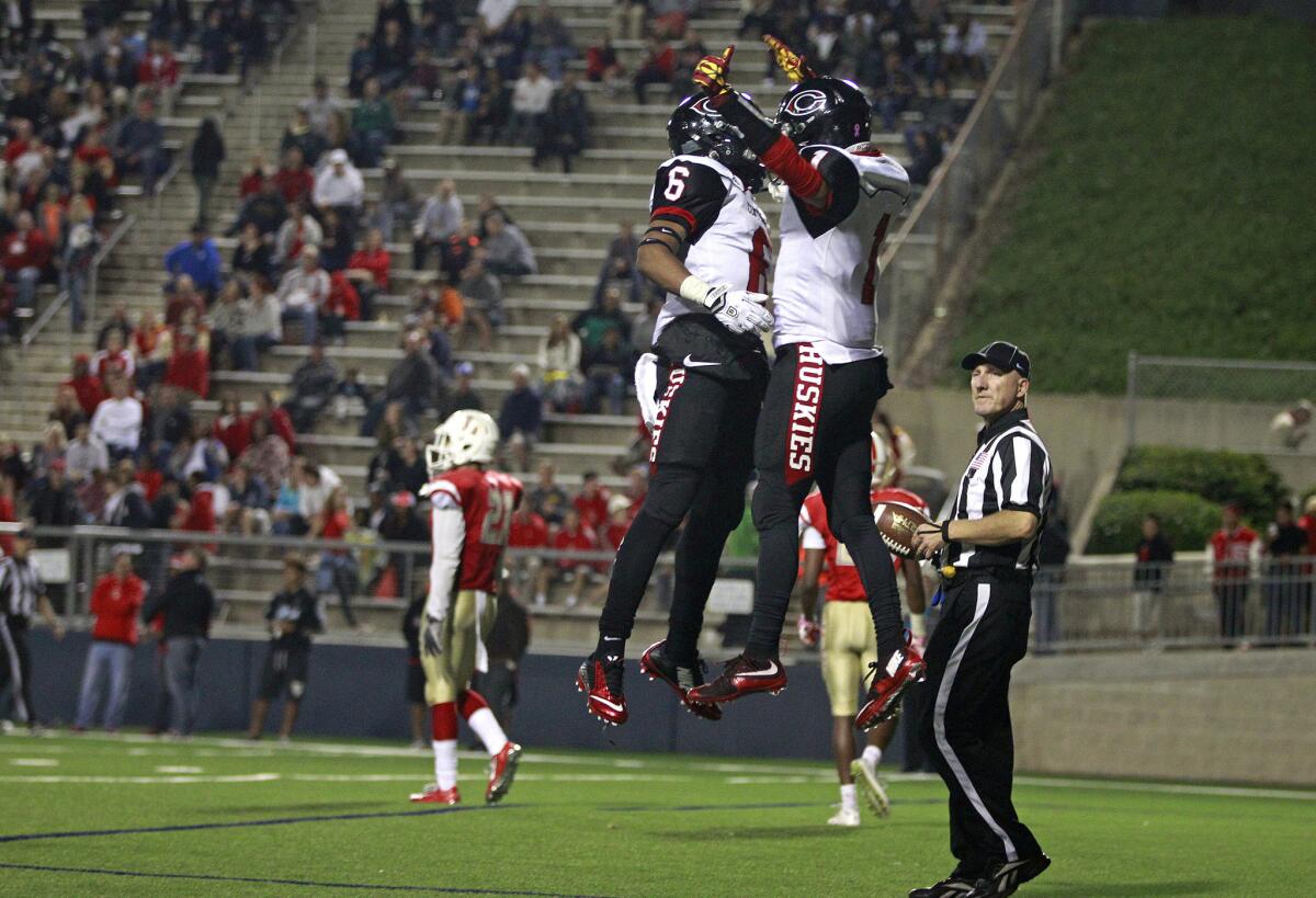 Corona Centennial wide receiver Cameron Jackson (1) celebrates with Sammonte Bonner (6) after Jackson scored late in the second quarter against Orange Lutheran on Nov. 20.