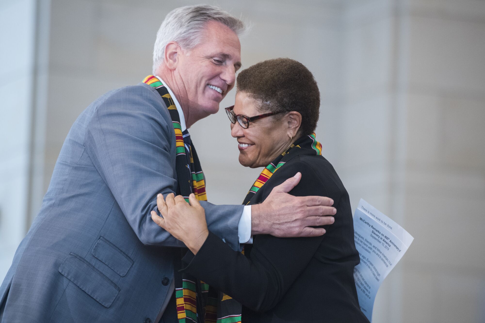 Reps. Kevin McCarthy and Rep. Karen Bass, wearing kente cloth scarves, embrace in the Capitol's Emancipation Hall in 2019.