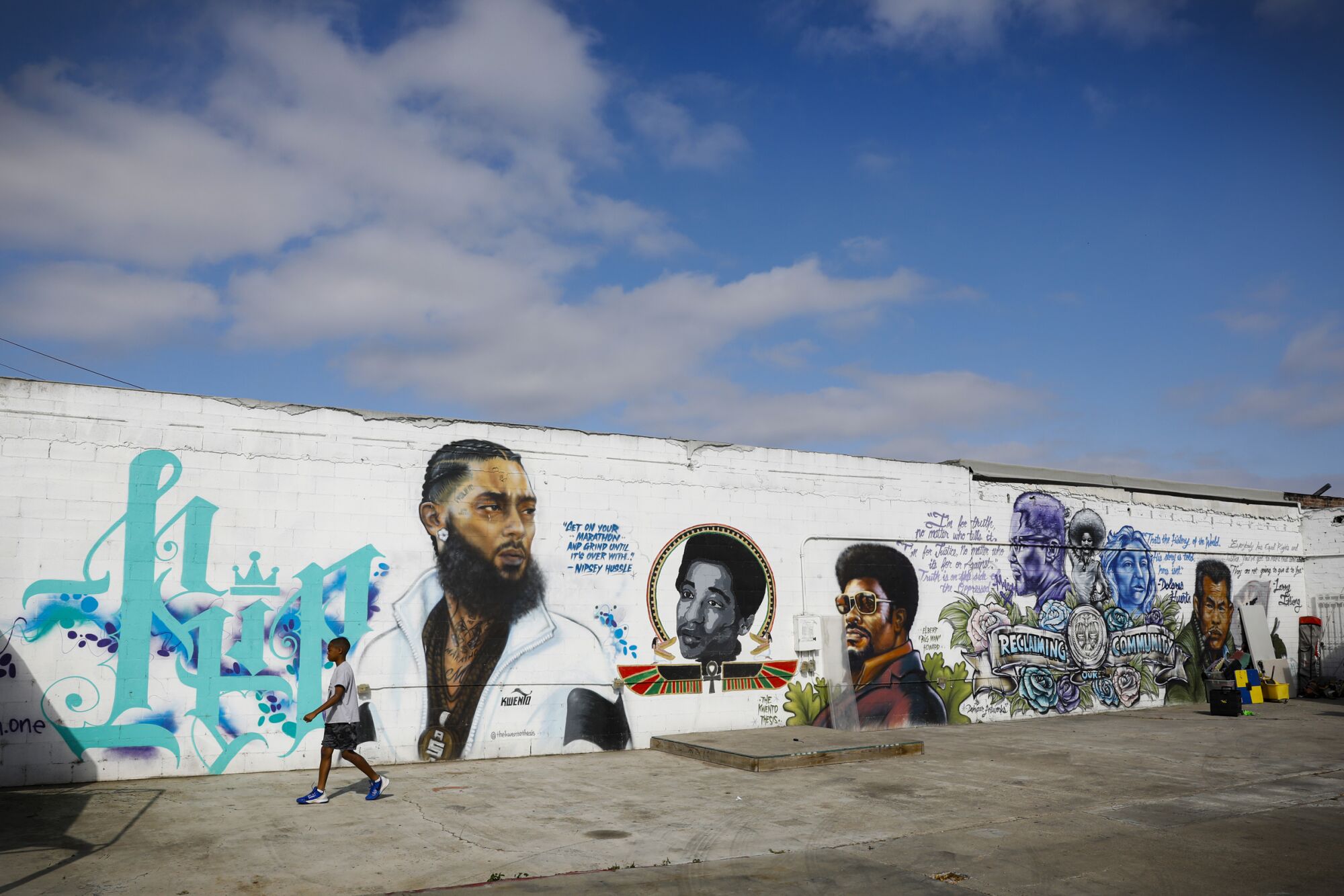A young boy walks by "mural alley" near 63rd and Imperial Avenue in the Encanto neighborhood.