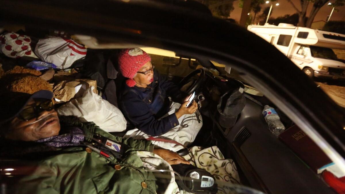 Lawrence McCue and Carla McCue bed down in their car in the Safe Parking LA area at the West Los Angeles VA campus in 2018.