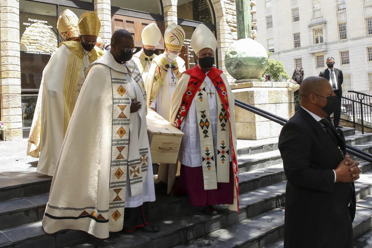 Clergy members carry the pine coffin of Archbishop Desmond Tutu from a chapel