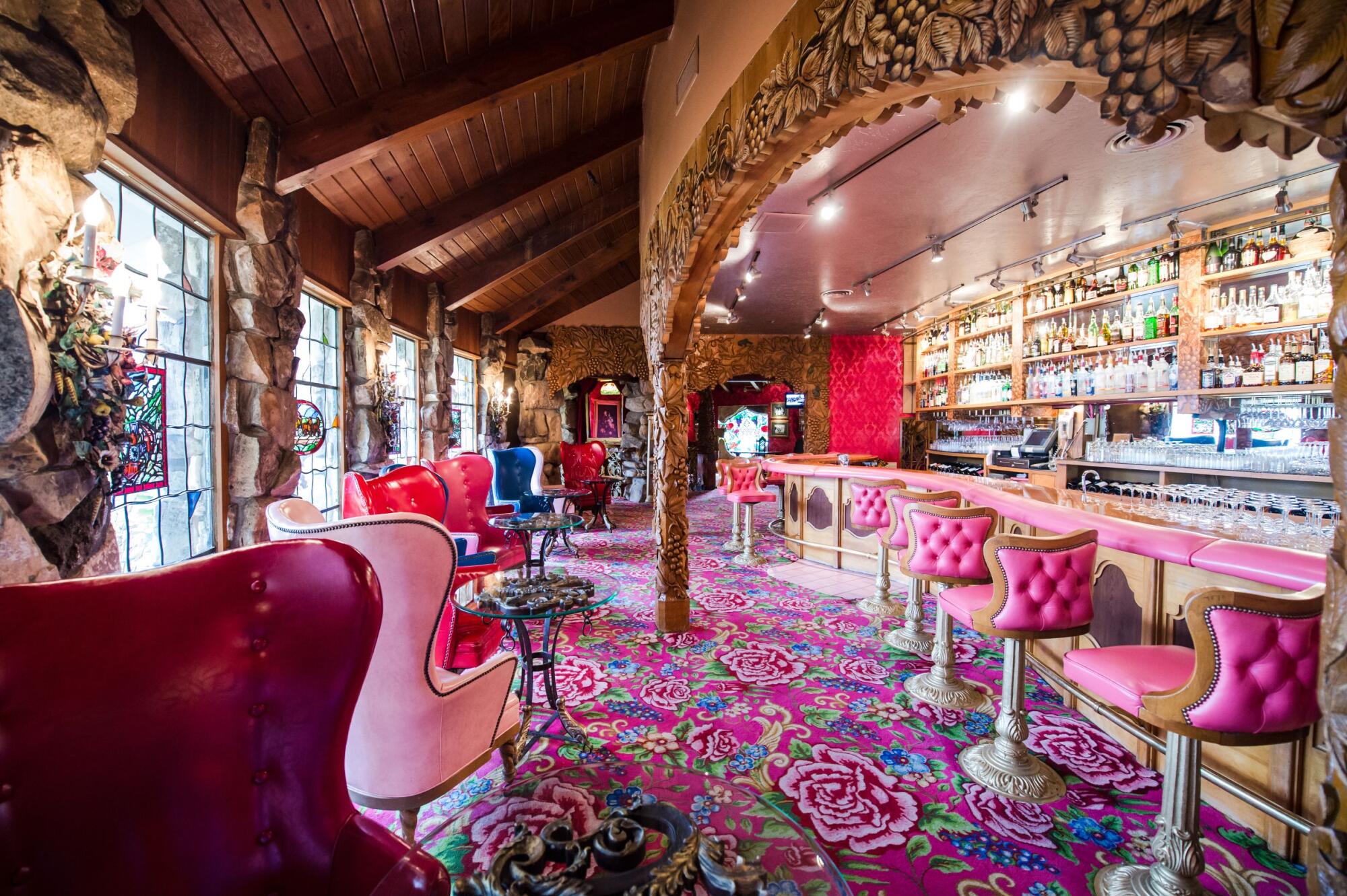 A colorful bar with various chairs at the Madonna Inn Silver Bar.