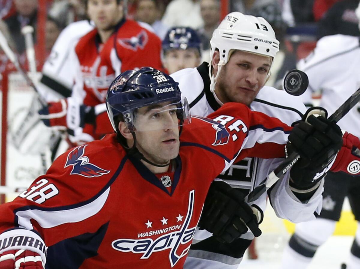 Capitals defenseman Jack Hillen and Kings forward Kyle Clifford keep their eye on the puck in a game last season.