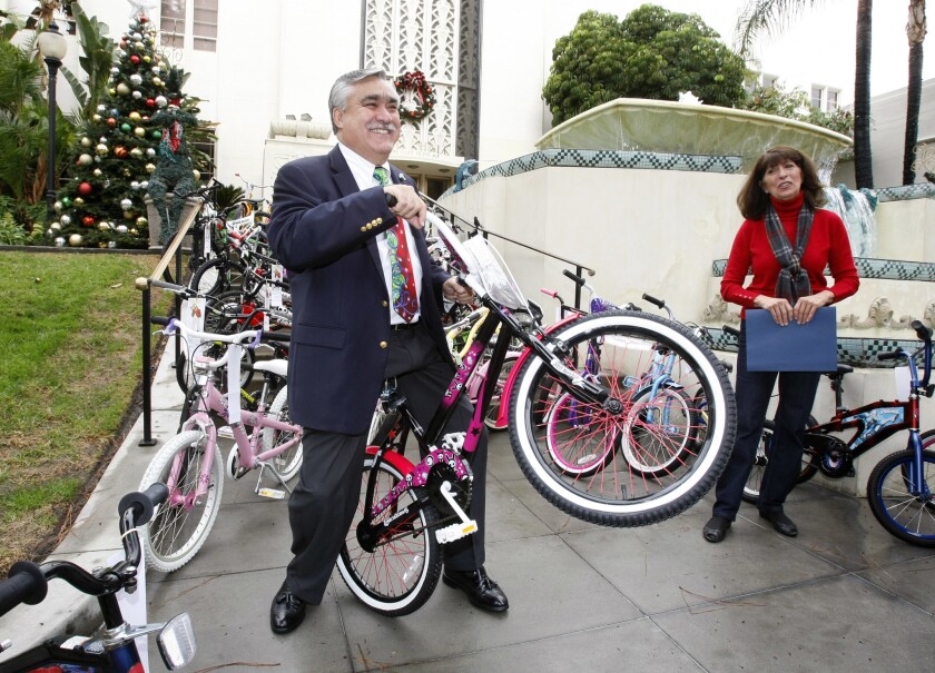 With Bike Angels director Elaine Pease looking on at right, Burbank Mayor Jess Talamantes shows off one of some 200 bicycles that will be donated during Christmas by the Burbank Salvation Army to local children.