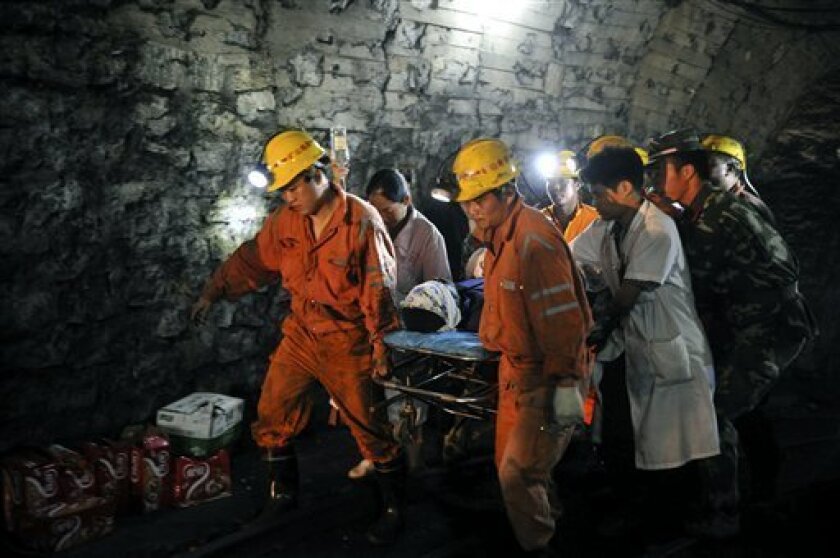 Liu Yunqing, the first miner rescued, is carried out on a stretcher from the flooded pit of Qielichong colliery in Sandu Township of Leiyang City, central China's Hunan Province, on Sunday, July 8, 2012. Chinese rescuers pulled to safety the first three of about a dozen miners trapped underground for more than three days in the flooded coal mine pit. (AP Photo/Xinhua, Bai Yu) NO SALES