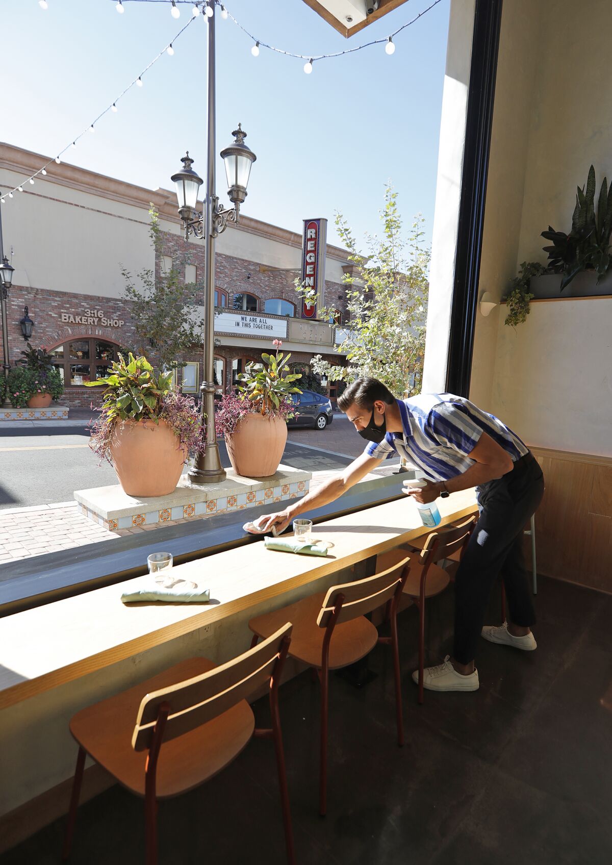 Owner George Barker opens the large bay windows at the new Mayfield restaurant in San Juan Capistrano.