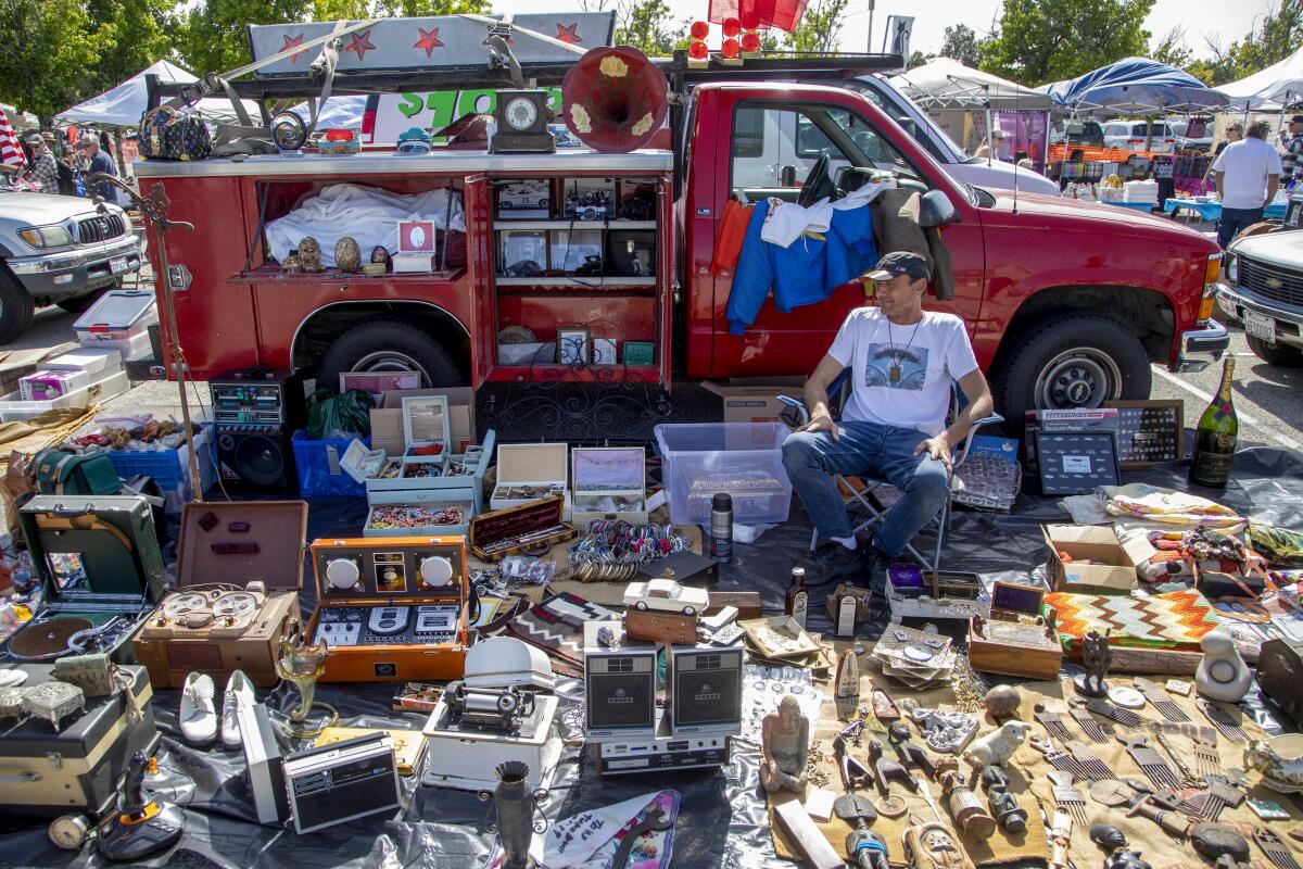 Shoppers view tiny figurines for sale at an outdoor market 