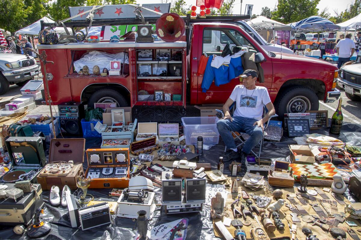 Shoppers view tiny figurines for sale at an outdoor market