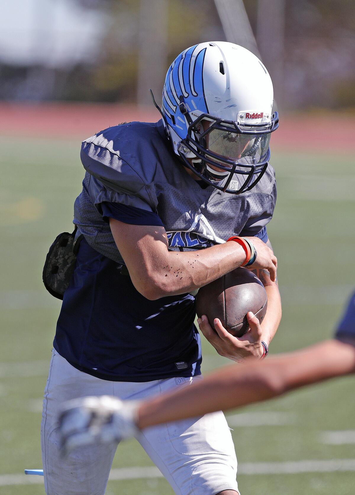 Crescenta Valley's Angel Ochoa runs with the ball during a drill at a preseason football practice at Crescenta Valley High School on Thursday, August 15, 2019.