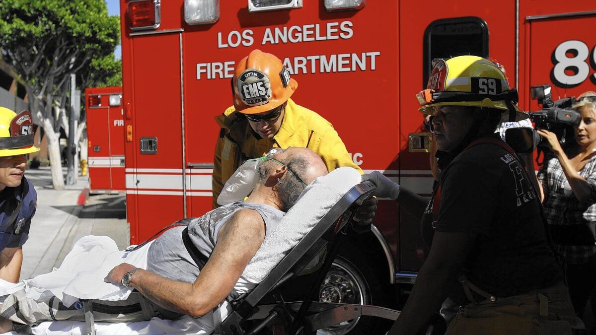 In L.A., the cost of an ambulance ride typically runs about $1,300. Above, a man is taken to an ambulance in L.A. in 2013.