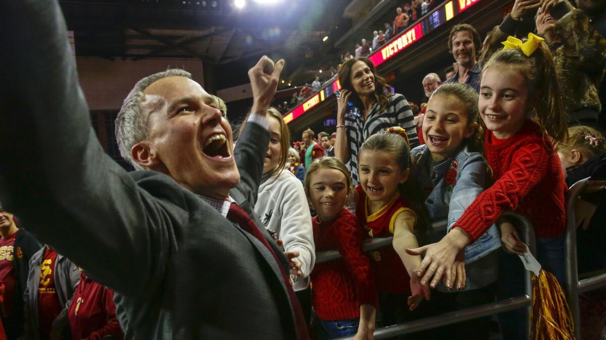 USC coach Andy Enfield celebrates with fans and family after the Trojans defeat the Arizona State Sundevils 69-67 at the Galen Center.