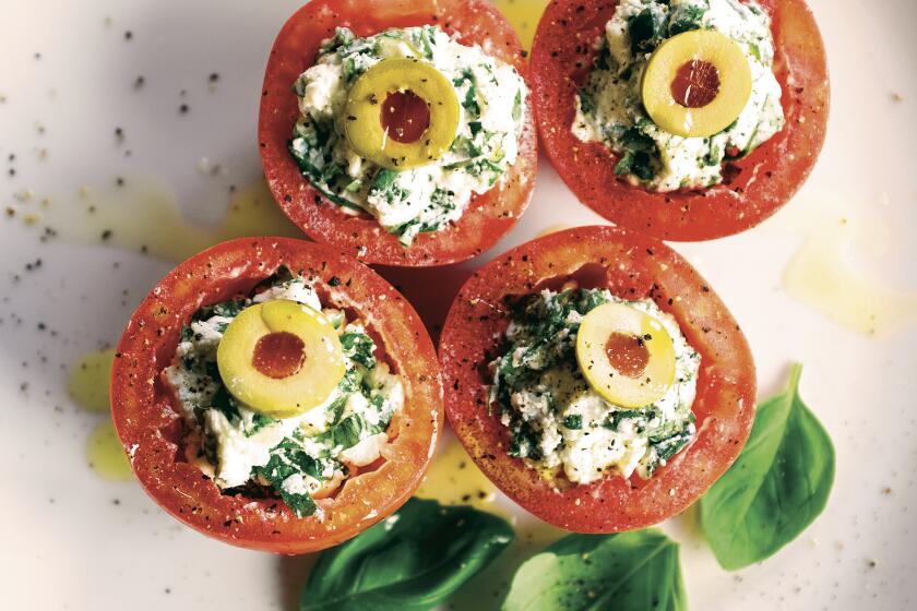 Tomatoes filled with whipped cheese and herbs topped by slices of green olives