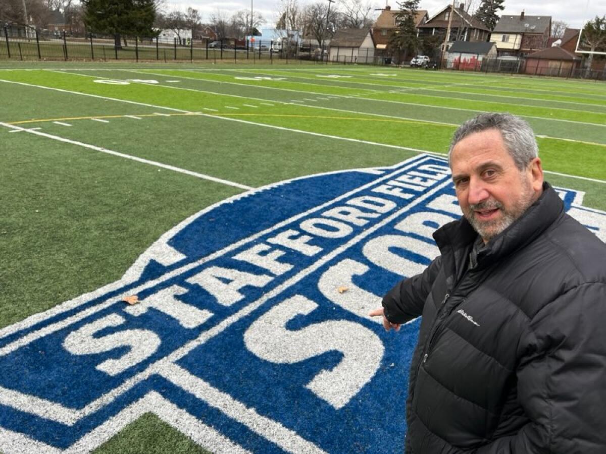 Marc Rosenthal, Chief Operations Officer von SAY Detroit, zeigt auf das Logo in der Mitte des Stafford Field.
