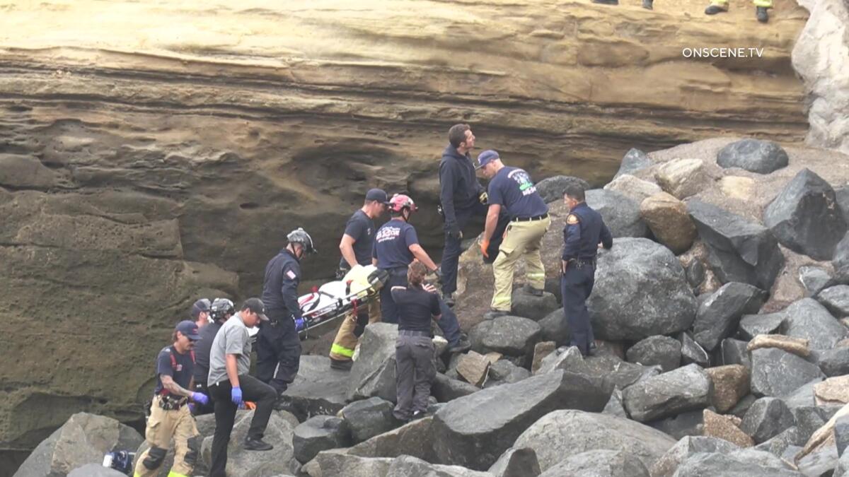 Crews recover a body found wedged in rocks at Sunset Cliffs on July 13. 