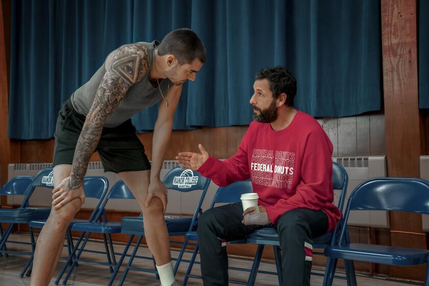 HUSTLE. (L-R) Juancho Hernangomez as Bo Cruz and Adam Sandler as Stanley Sugerman in Hustle. Cr. Scott Yamano/Netflix  2022.