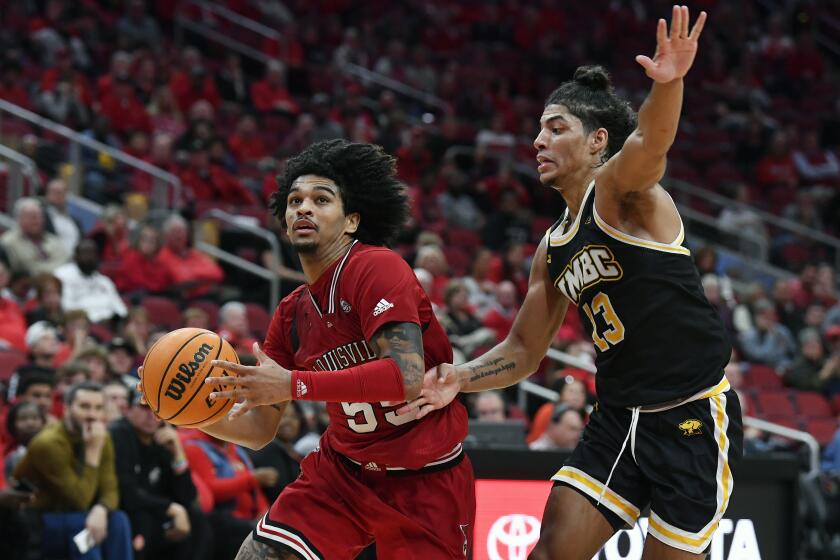 Louisville guard Skyy Clark drives past Maryland Baltimore County guard Dion Brown 