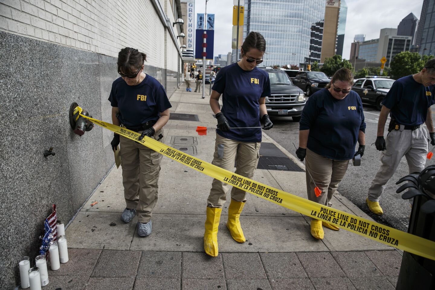 Investigators comb through the crime scene for evidence outside El Centro College on Lamar Street in Dallas where a gunman killed five police officers and wounded seven others.