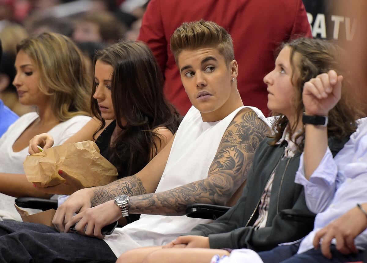 Justin Bieber, center, attends a Clippers game on May 11.