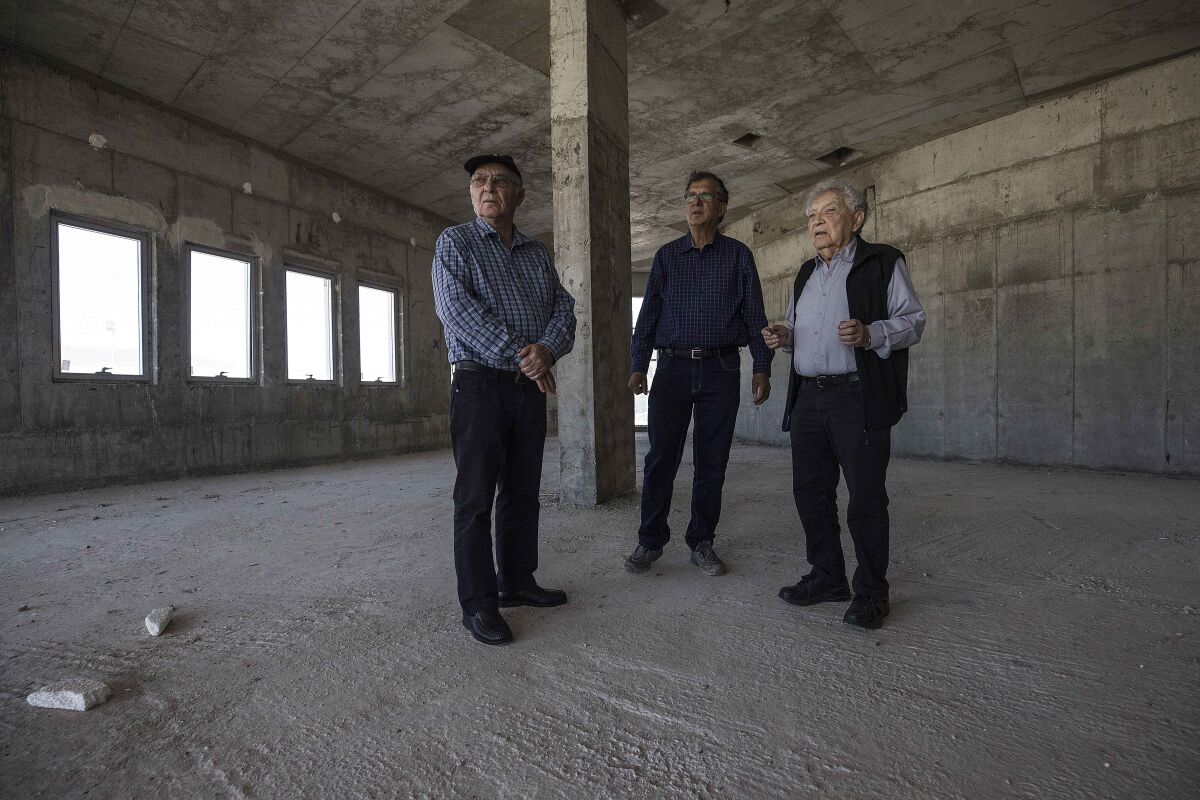 FILE - In this Tuesday, April 18, 2017 file photo, Jewish World War II veterans Chaim Erez, left, Zvi Kan-Tor, center, and Yitzhak Arad stand during an interview with The Associated Press inside the unfinished museum honoring Jewish World War II veterans, in Latrun, Israel. Arad, a Holocaust survivor and scholar who was the director of Israel's Yad Vashem Holocaust memorial for more than two decades, has died at the age of 94, Thursday, May 6, 2021. (AP Photo/Tsafrir Abayov, File)