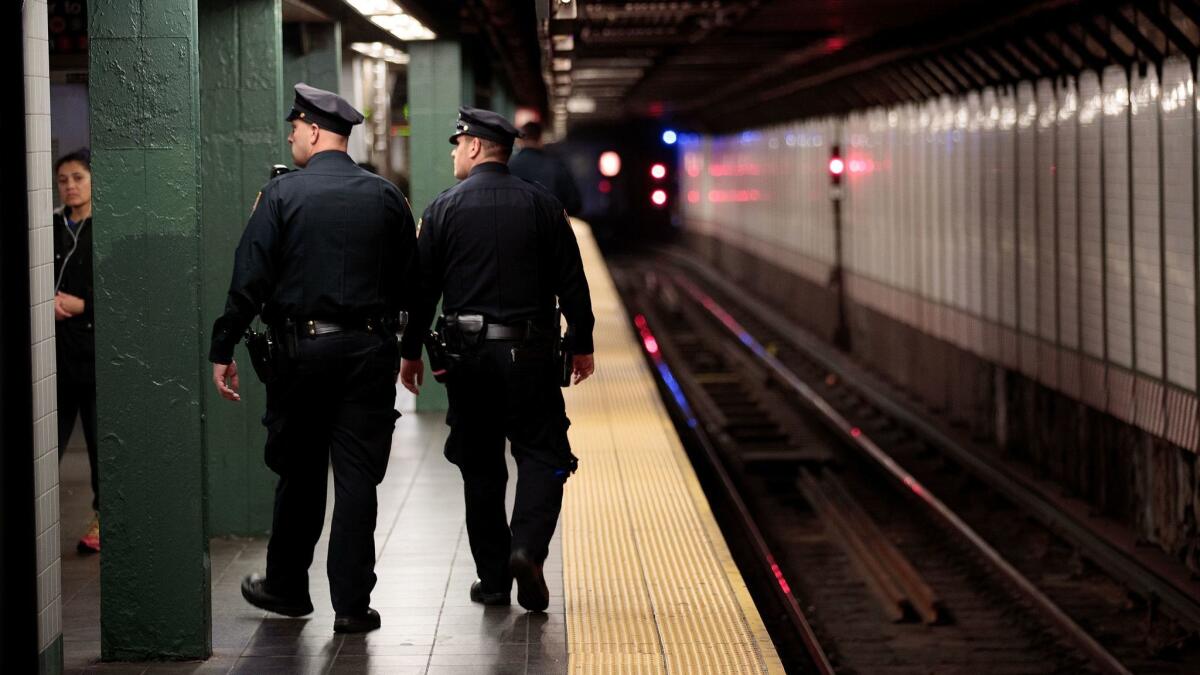 New York City police officers patrol the subway station in Times Square on Monday, before a commuter was pushed in front of an oncoming train.