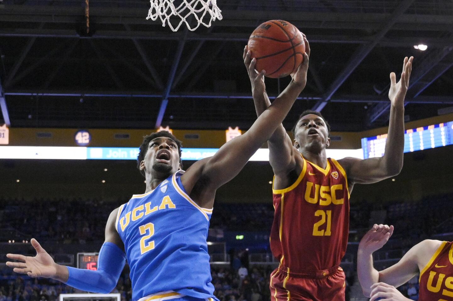 UCLA forward Cody Riley and USC forward Onyeka Okongwu reach for a rebound during the first half of a game Jan. 11 at Pauley Pavilion.