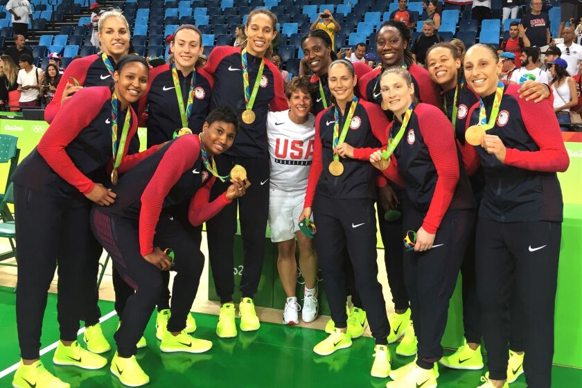 Ilene Hauser, center, poses for a photo with the gold-medal U.S. national basketball team at the Rio Summer Games in 2016.