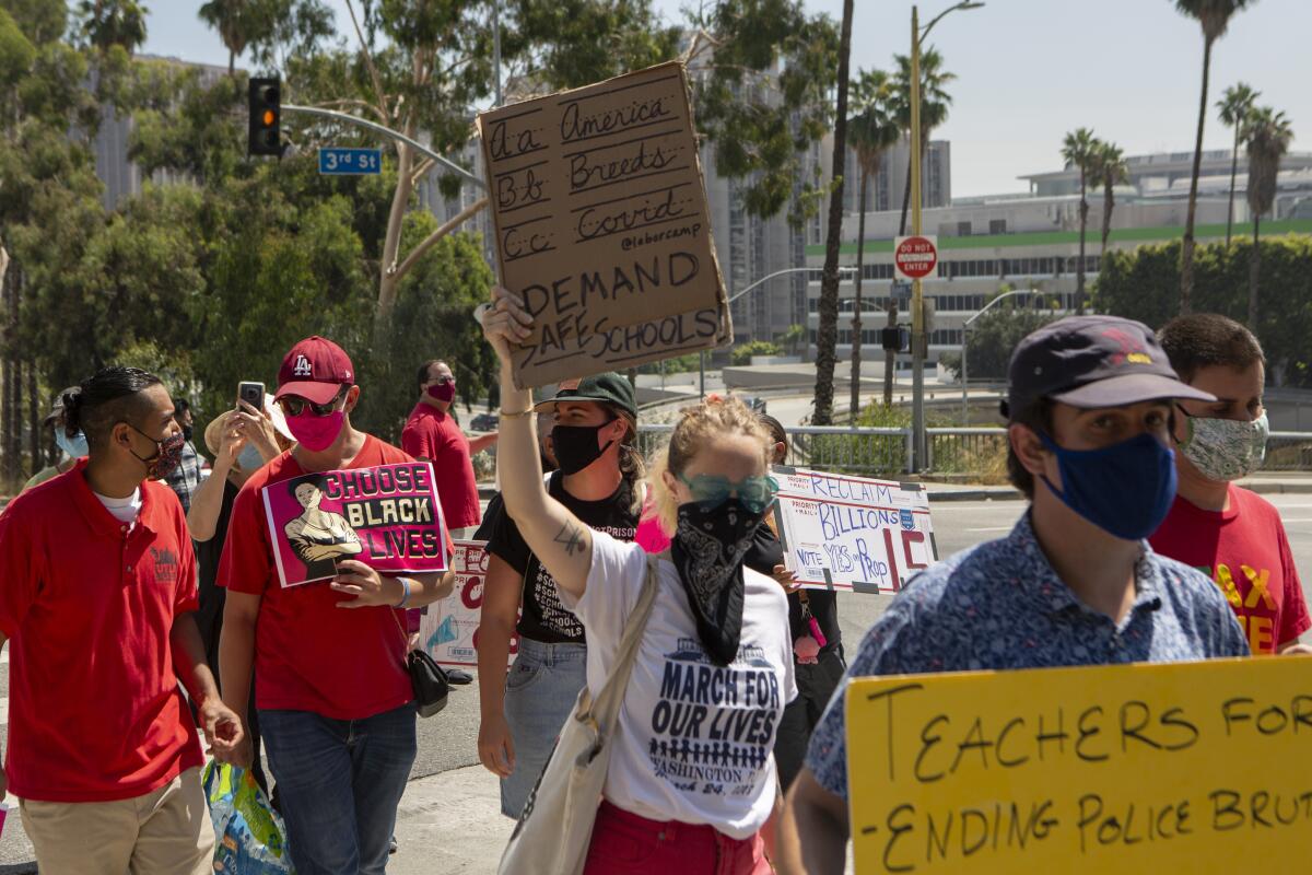 Teachers union members and others march Aug. 3 to demand a safer approach to reopening schools.