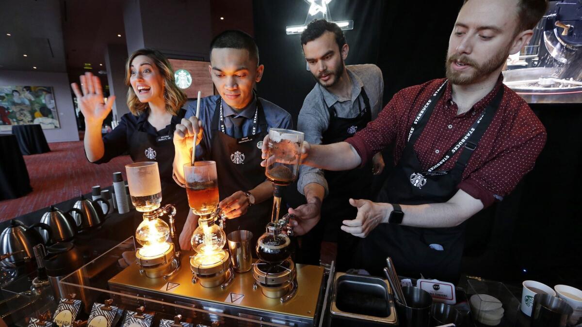 Baristas from Starbucks' specialized coffee shop, Reserve Roastery, demonstrate a siphon brew of individual cups of coffee.