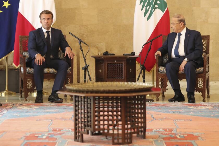 French President Emmanuel Macron, left, and Lebanese President Michel Aoun meet at Beirut airport, Lebanon, Thursday Aug.6, 2020. French President Emmanuel Macron has arrived in Beirut to offer French support to Lebanon after the deadly port blast.(AP Photo/Thibault Camus, Pool)
