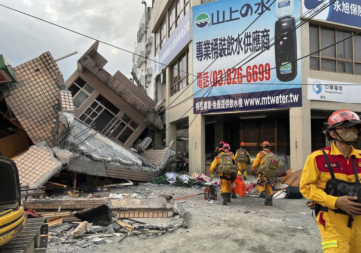 Emergency workers near a collapsed residential building after Sunday's earthquake.