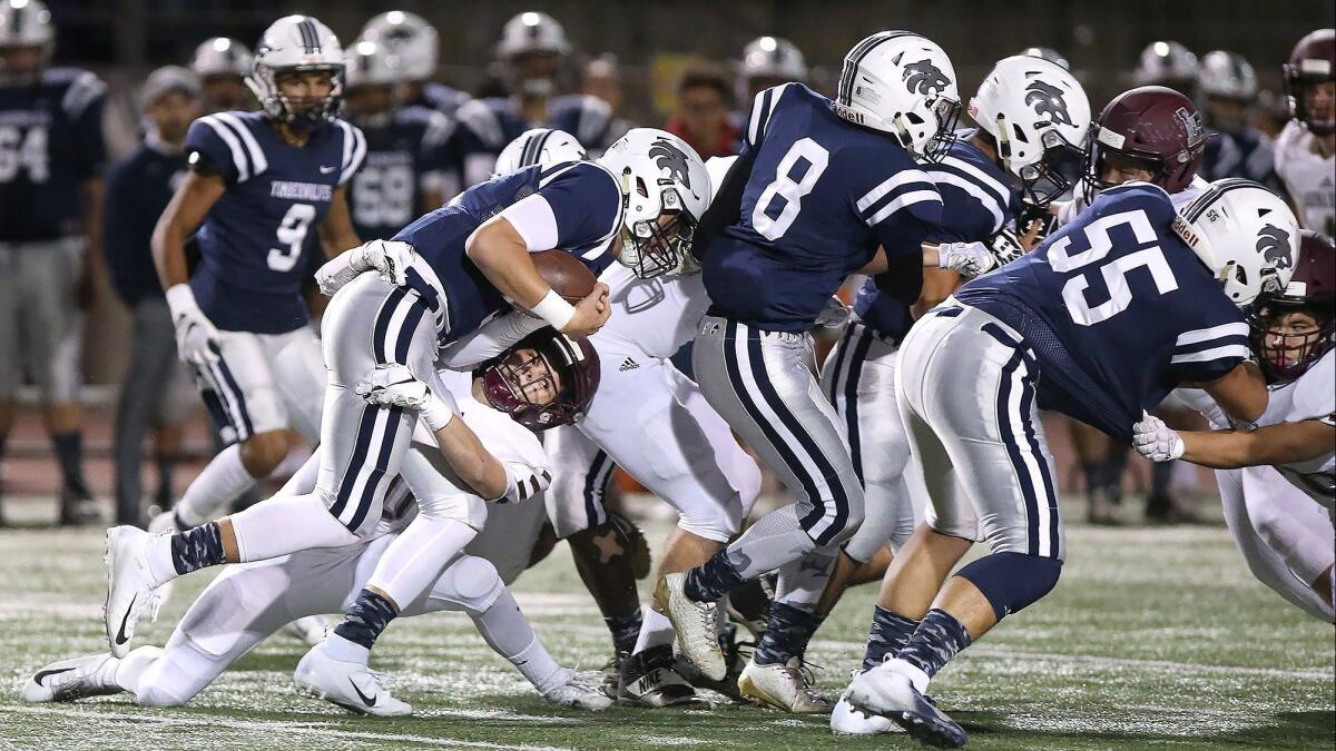 Laguna Beach High linebacker Shane Lythgoe drags down Northwood quarterback Jaden Piazza for a loss in the quarterfinals of the CIF Southern Section Division 12 playoffs at Irvine High on Friday.