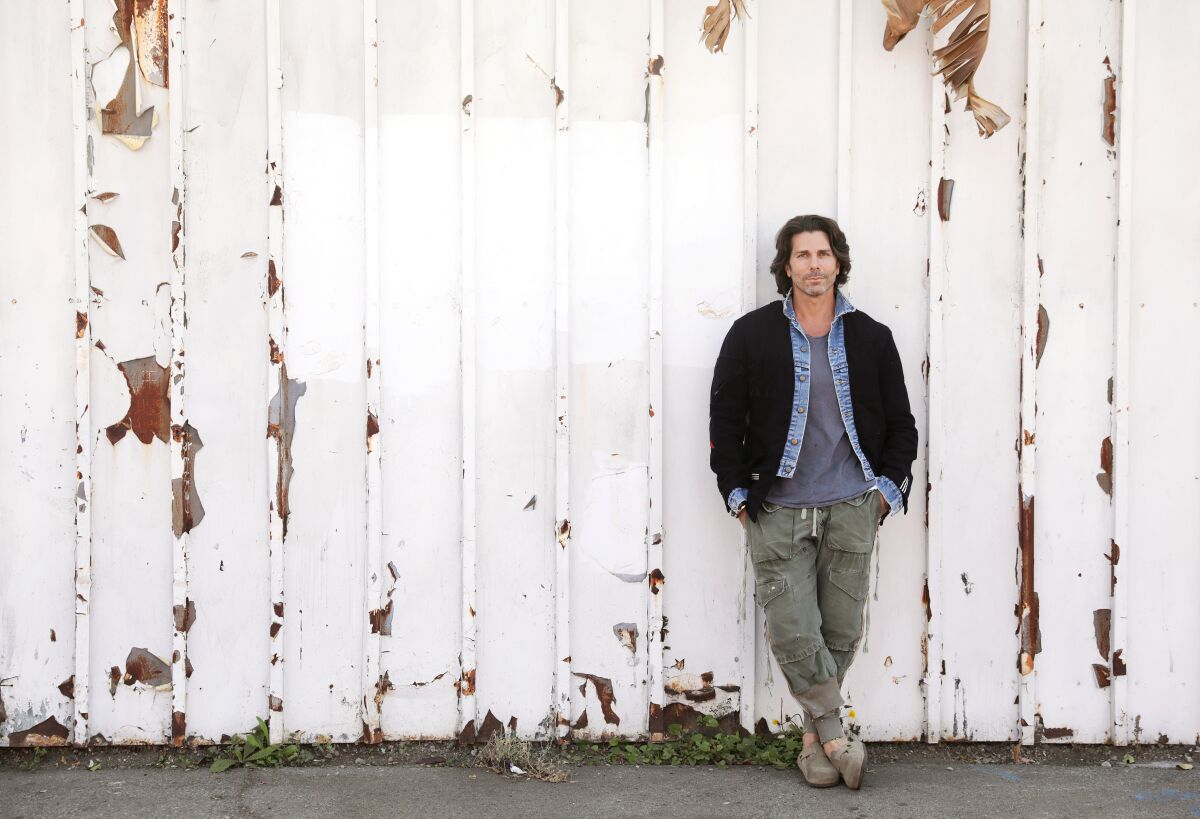 L.A.-based designer Greg Lauren leans against a wall at his downtown L.A. warehouse.