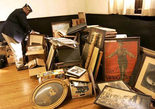 Veteran Hugh Crooks searches through piles of military memorabilia at Bob Hope Patriotic Hall.
