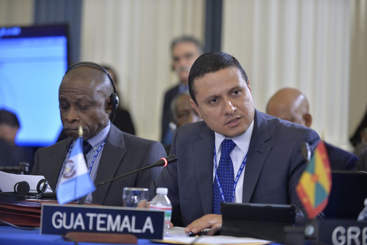 SHM54. WASHINGTON (DC, EEUU), 15/06/2015.- Fotografía cedida por la OEA en donde aparece el canciller de Guatemala, Carlos Raúl Morales (d), durante su intervención ante la 45ª Asamblea General de la Organización de Estados Americanos (OEA), celebrada hoy, lunes 15 de junio 2015, en Washington, DC (EE.UU.). La Asamblea General de la OEA aprobó hoy por aclamación una resolución de apoyo al Gobierno de Guatemala ante las protestas sociales que desde el 25 de abril piden la dimisión del presidente, Otto Pérez Molina, sobre el que pesan sospechas de corrupción. EFE/Juan Manuel Herrera/SOLO USO EDITORIAL/NO VENTAS