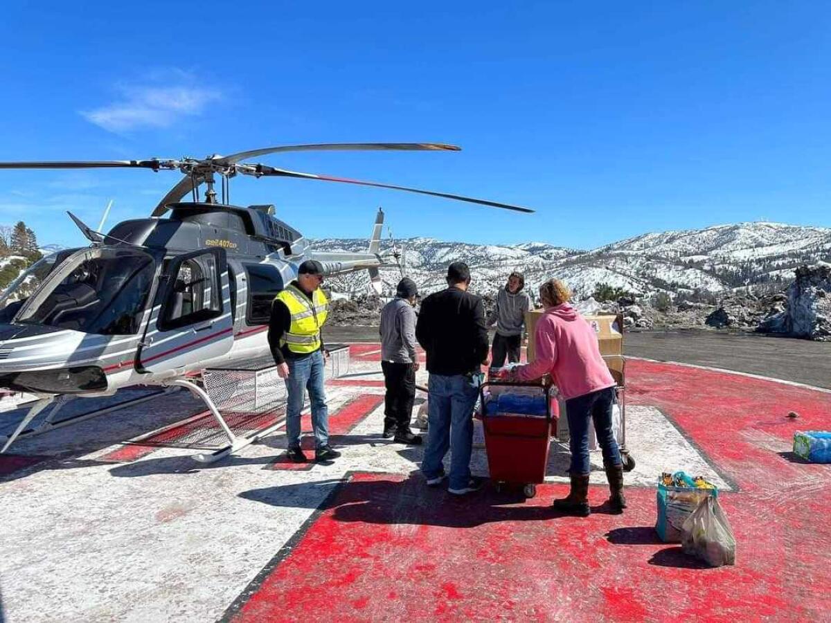 A CalDART team delivered supplies to snowed-in residents around Lake Arrowhead via helicopter drops Friday. 